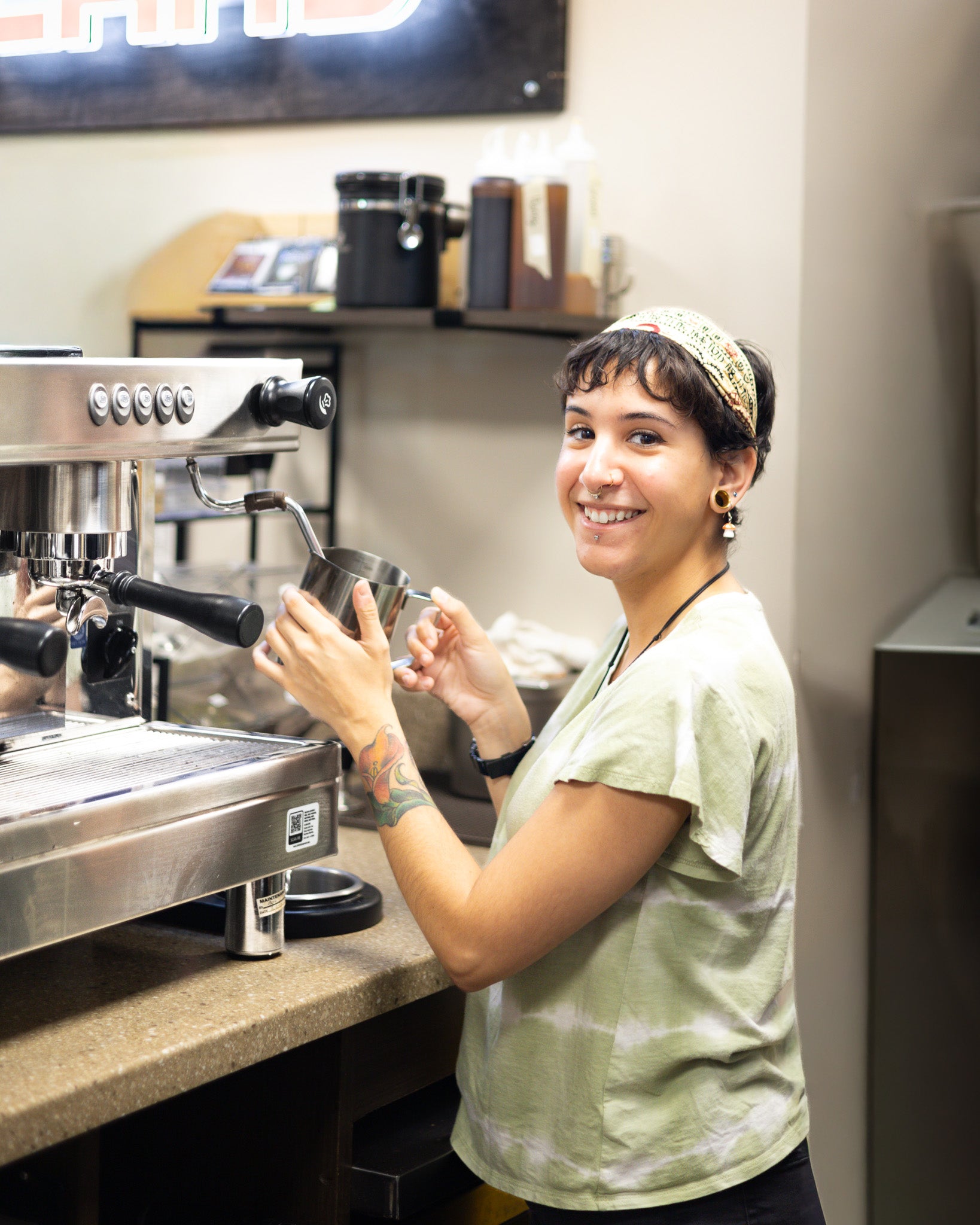 Woman working with a coffee machine in a cafe setting