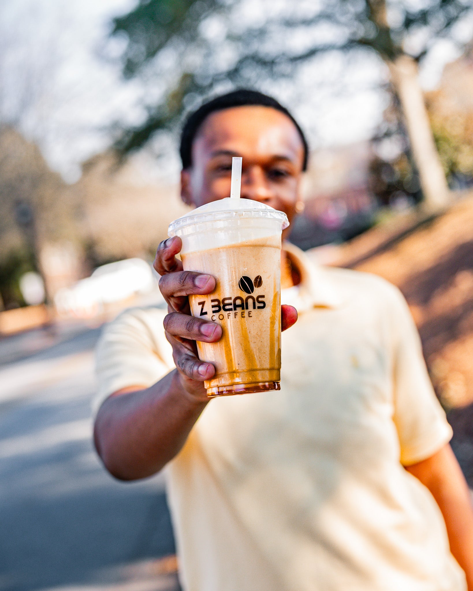 Person holding a iced coffee from Z Beans Coffee outdoors