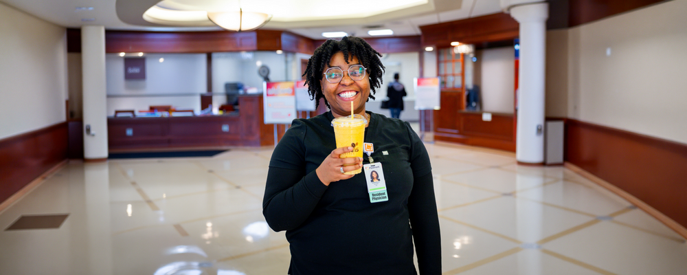 Person holding a drink in a building lobby